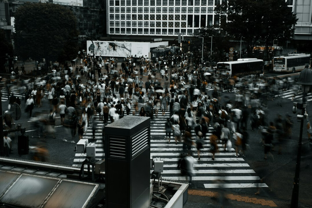 Person walking across a city crosswalk at a busy intersection