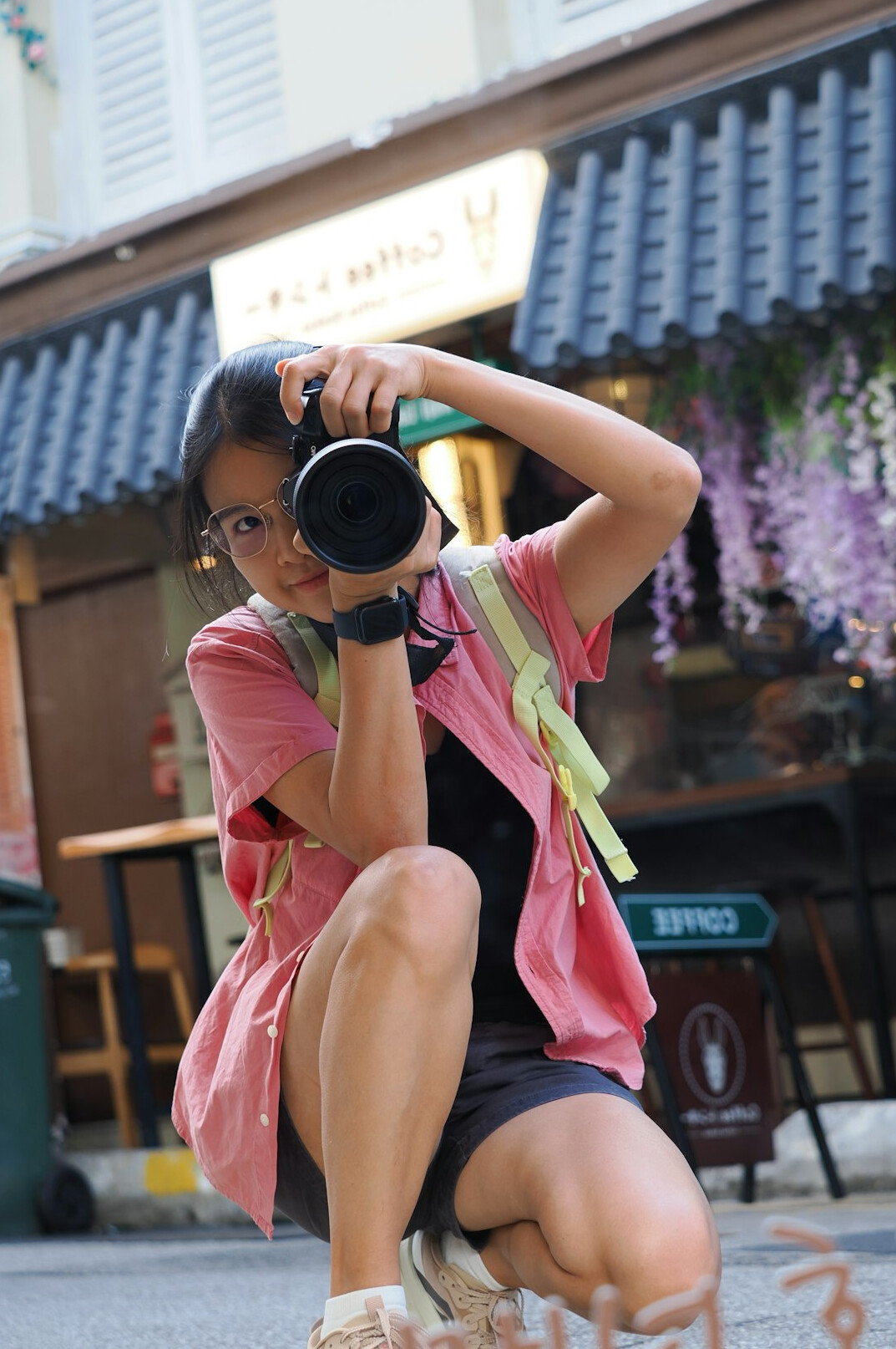 Photographer crouching to take a photo of a street scene