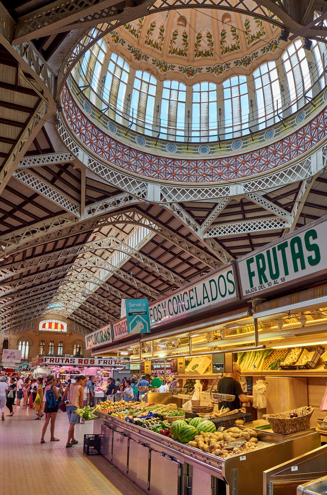 Interior of a covered central market with fruit and vegetable stands